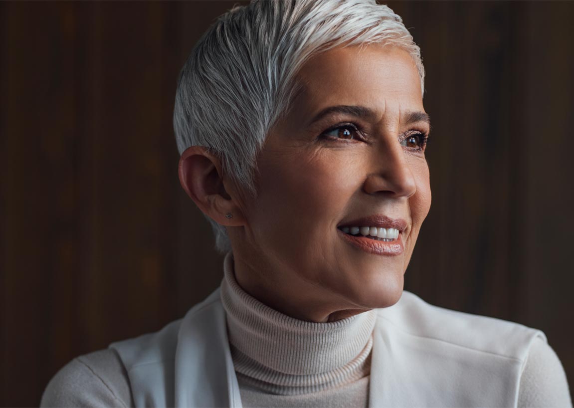 professional woman with short white hair looking into camera